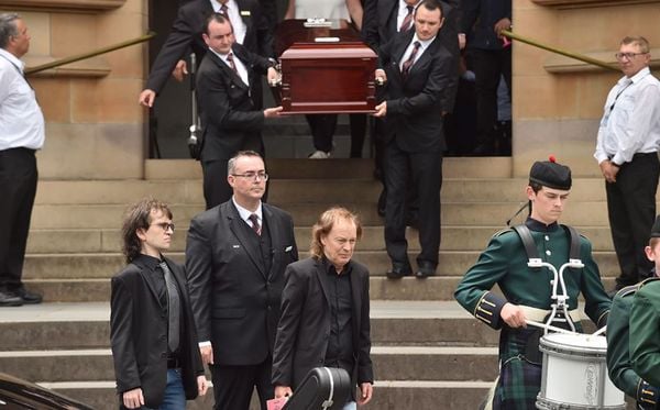 O guitarrista do grupo de rock AC/DC Angus Young deixa deixa a Catedral de Santa Maria carregando um violão após o funeral do seu irmão, guitarrista e co-fundador da banda  Malcolm Young em Sidney, Austrália  por PETER PARKS/AFP