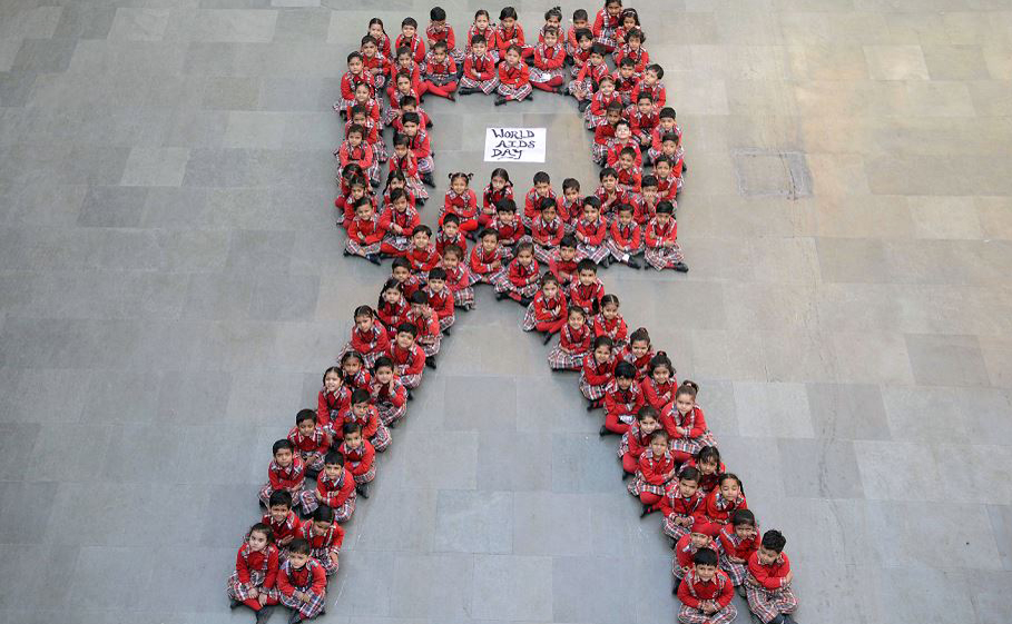 Alunos indianos formam o símbolo da campanha contra a AIDS , na véspera do dia mundial da luta contra a doença.  por NARINDER NANU / AFP