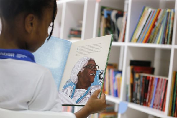 Criança da Escola Eugênia Ana dos Santos, com livro de Mãe Stella