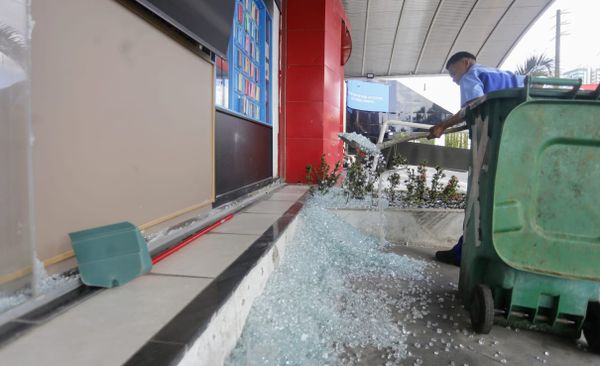 Funcionários recolhem estilhaços de vidros no Shopping da Gente