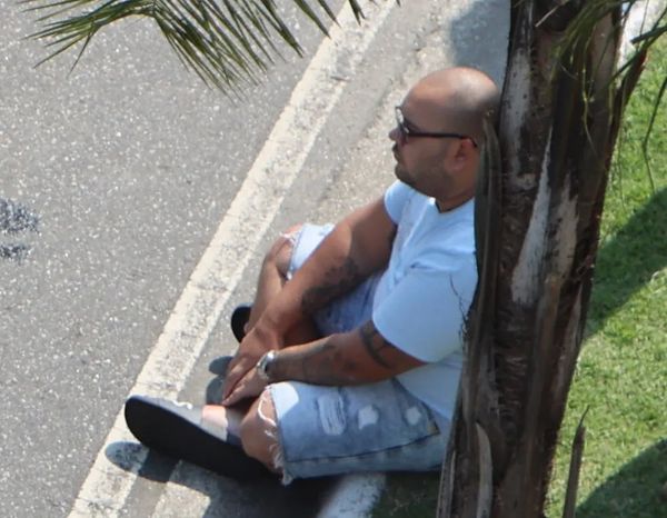 Taillon sentado no meio-fio durante abordagem da PF na Barra da Tijuca