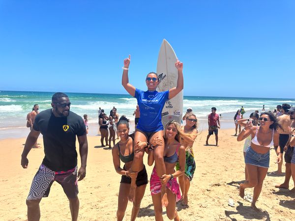 Tainá Hinckel é carregada na praia de Stella Maris