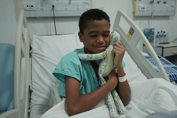 Aslam dos Santos de 11 anos abraçando seu novo companheiro