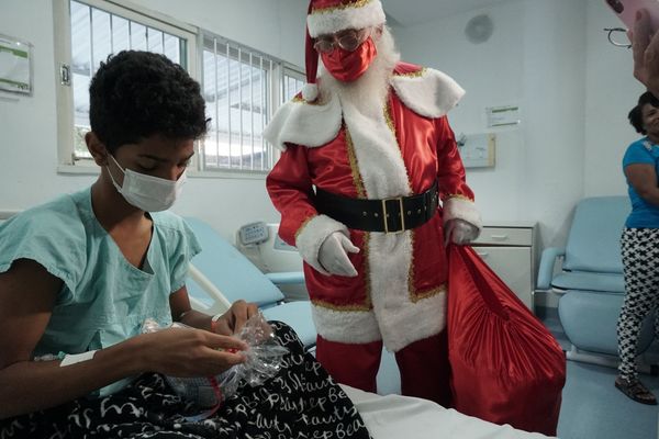 Papai Noel fazendo a entrega para Ariel Firmo de 14 anos 