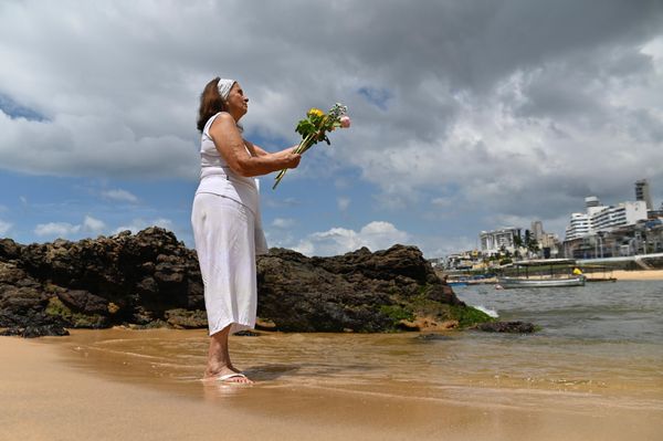 Marinalva  banha as rosas com alfazema antes de entregar o a Iemanjá