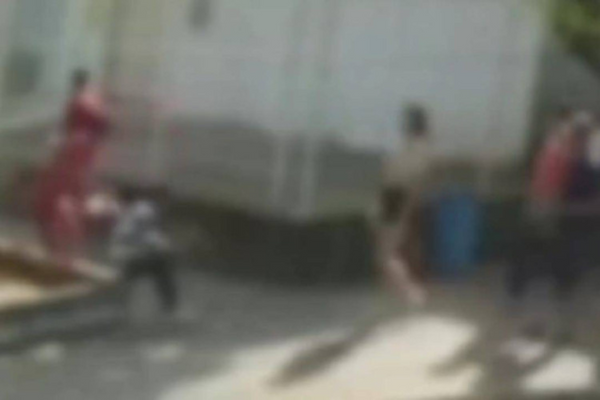 À esquerda, o suspeito, vestindo camisa vermelha, aparece jogando líquido inflamável na vítima, de camisa listrada, que está sentada