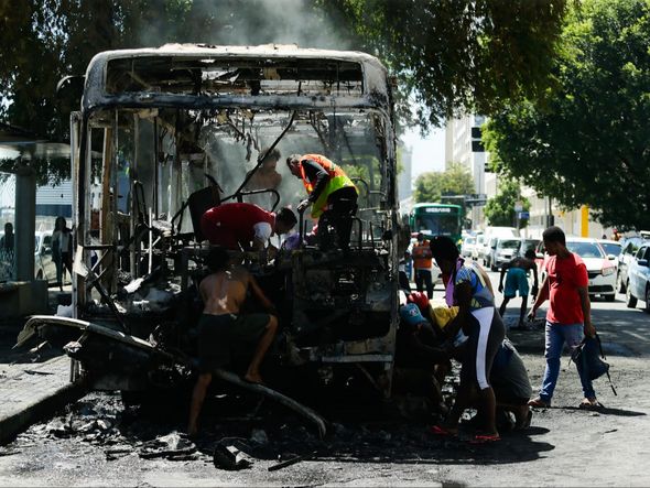 Imagem - Vândalos saquearam ônibus com o veículo ainda em chamas
