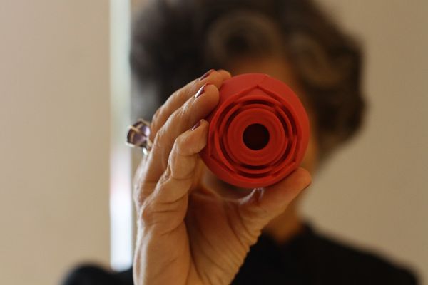 Margarida segurando um sugador de clitóris em formato de flor