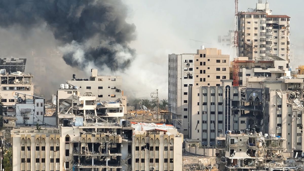 Fumaça subindo atrás de prédios destruídos em Gaza