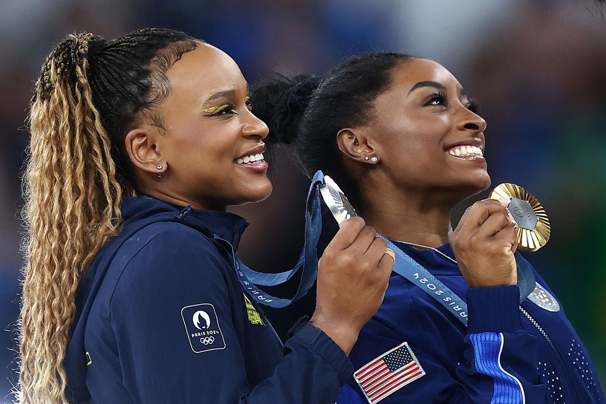 Rebeca e Simone Biles posam para foto no pódio