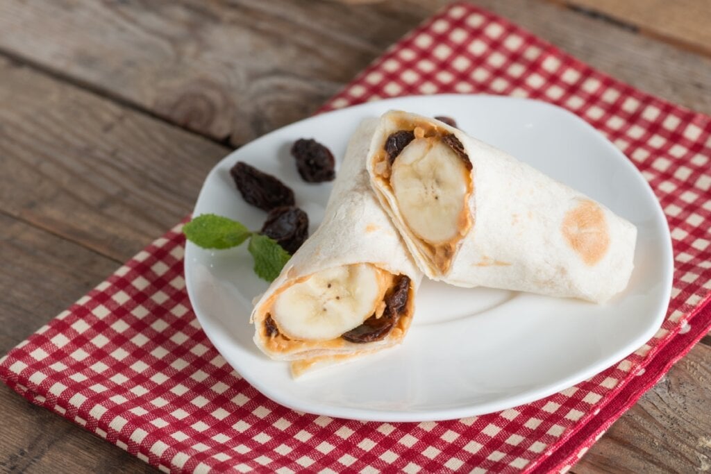 [Edicase]Tortilha de banana, pasta de amendoim e uvas-passas (Imagem: inewsfoto | Shutterstock) por  