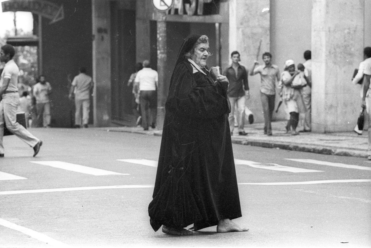 Descalça e de traje roxo aveludado a Dama da Rua Chile caminha pela rua