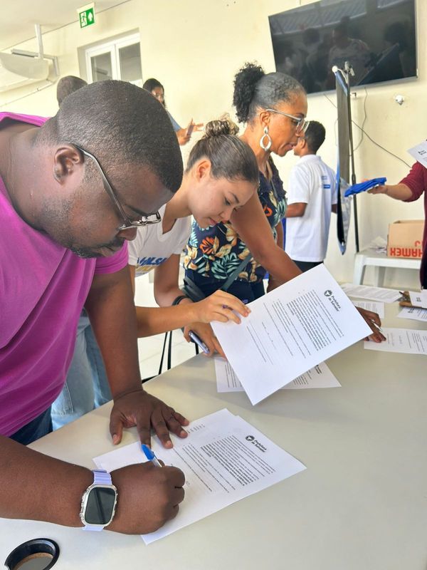 Atletas assinando o termo de acesso à ajuda de custo