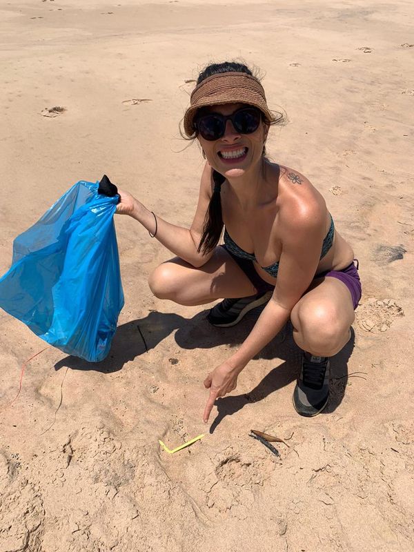 Mariana catando lixo em praia na Península de Maraú, na Bahia