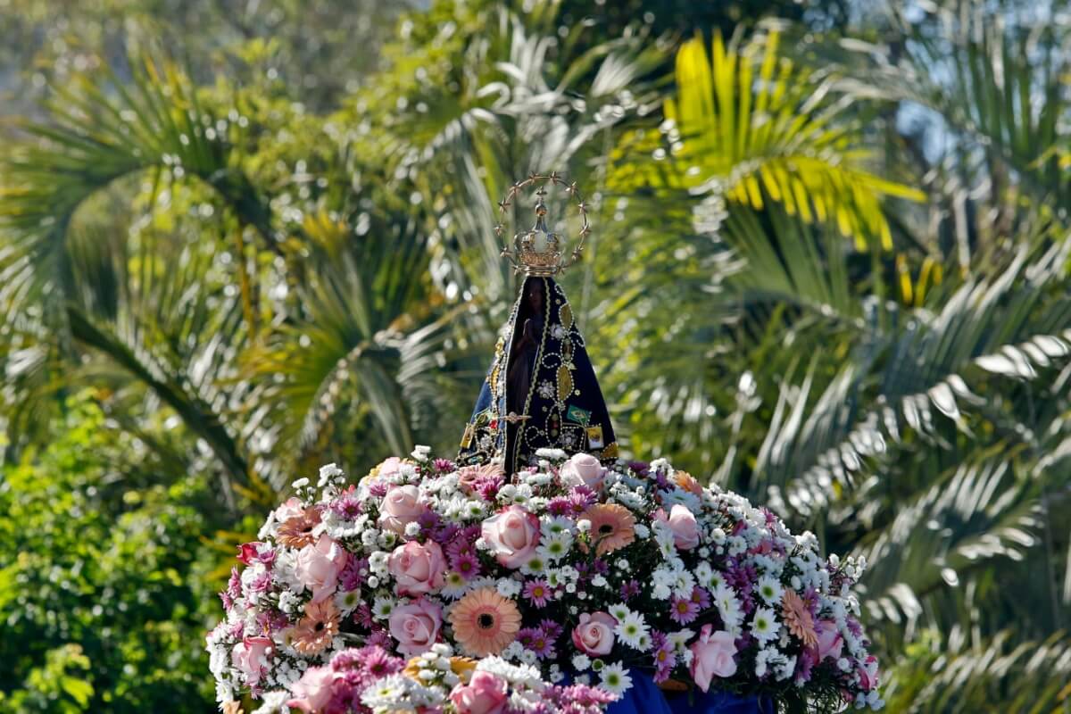 Oferecer flores à Nossa Senhora Aparecida é um gesto de fé e devoção por Imagem: Sidney de Almeida | Shutterstock