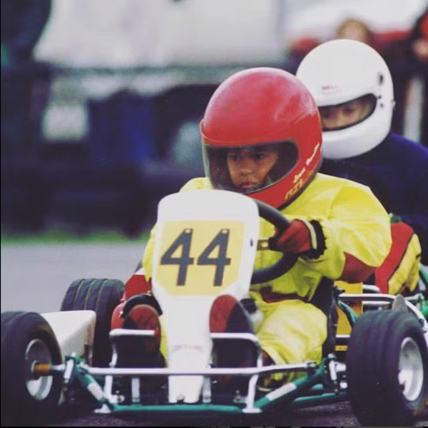Hamilton dirigindo kart com capacete vermelho na infância