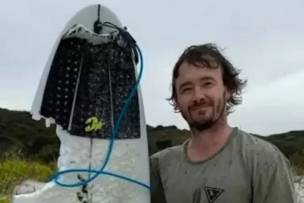 Surfista com a prancha quebrada pelo tubarão