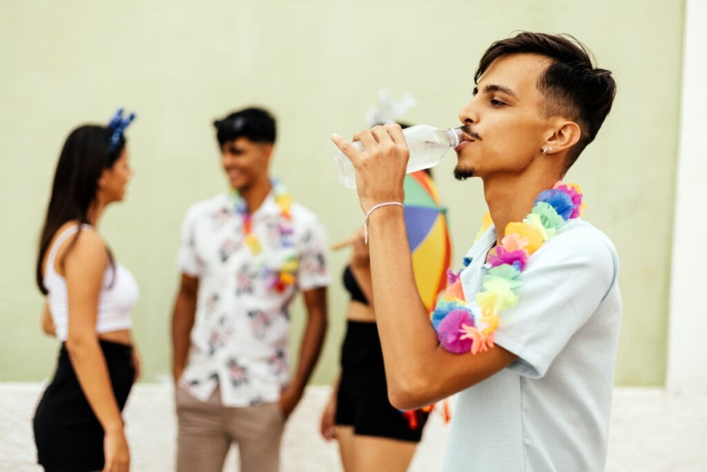 Beber água durante a folia ajuda a prevenir a desidratação (Imagem: Kleber Cordeiro | Shutterstock)