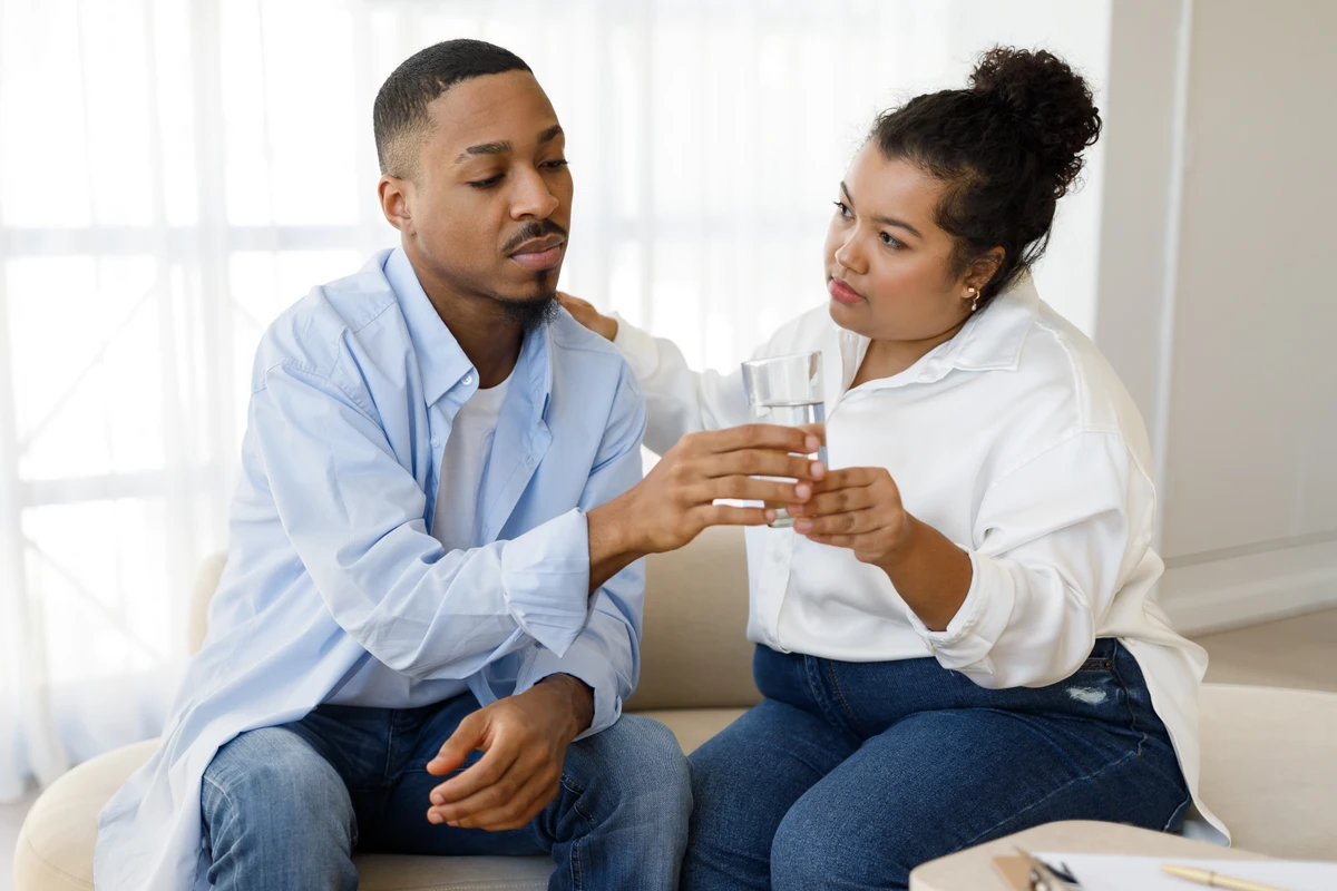 Mulher oferece água para homem ansioso