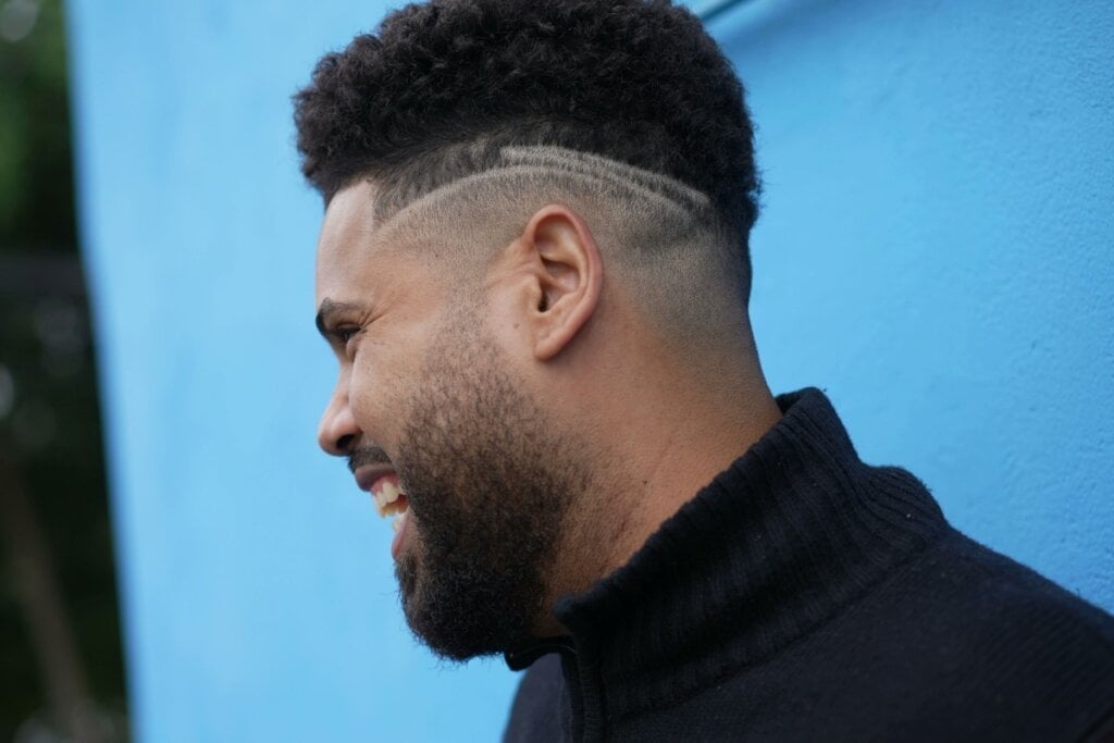 O afro fade é ideal para quem busca praticidade sem abrir mão do estilo (Imagem: Bricolage | Shutterstock)
