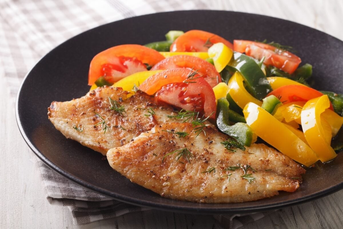 Filé de tilápia com vegetais salteados (Imagem: Sergii Koval | Shutterstock)