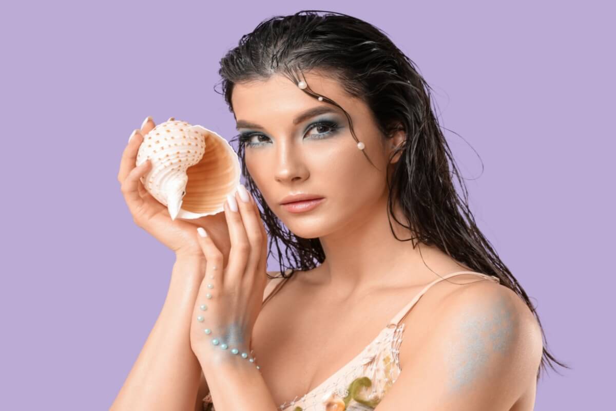 Tons azulados, pele iluminada e brilho molhado compõem o look conhecido como mermaidcore (Imagem: Pixel-Shot | Shutterstock)