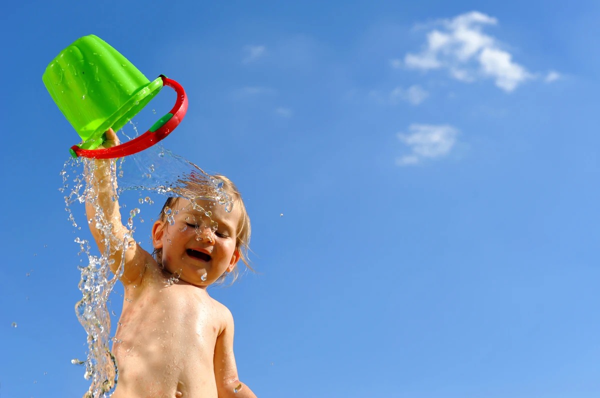 Criança brincando na praia por Shutterstock