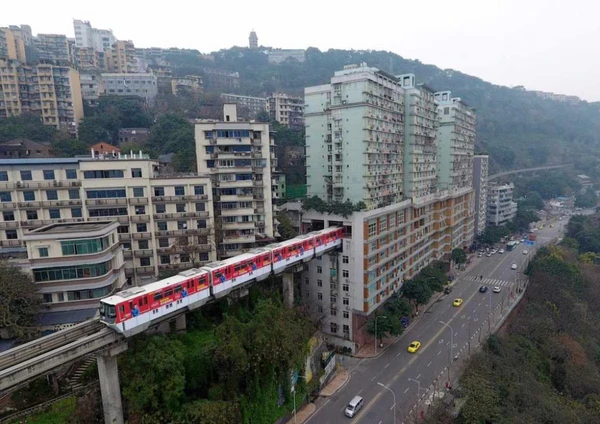 Trem passa por prédio em Chongqing por Reprodução