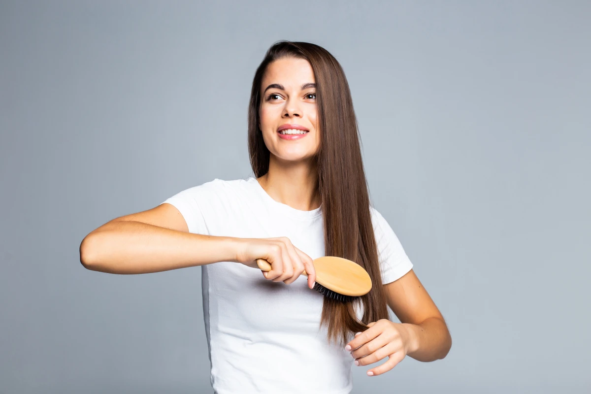 Young woman combing her hair isolated on white background por Reprodução | Freepik