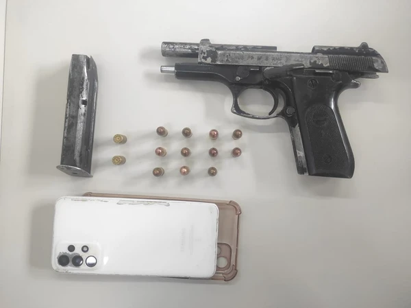 Arma e celular apreendidos pela polícia por Divulgação