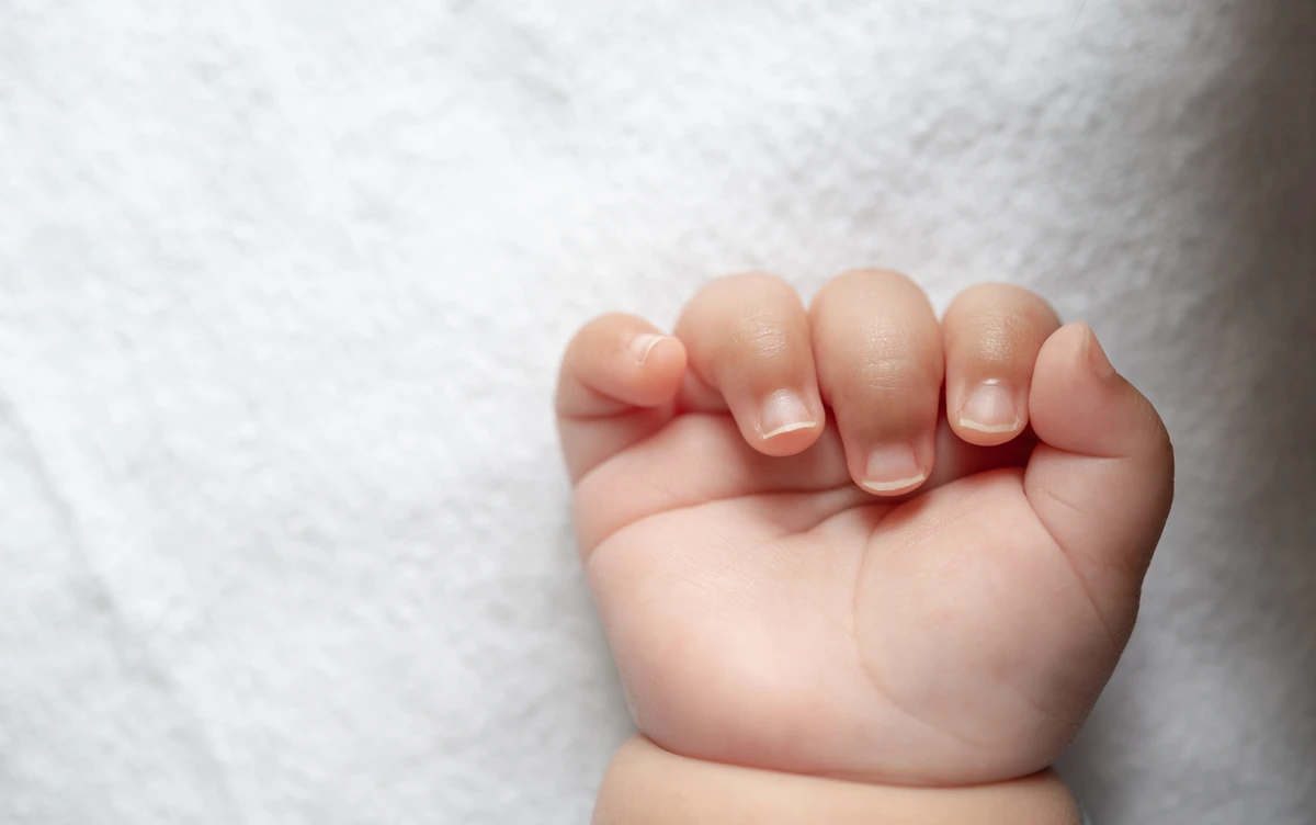 Newborn baby hand in white bed. Selective focus. por Reprodução | Freepik
