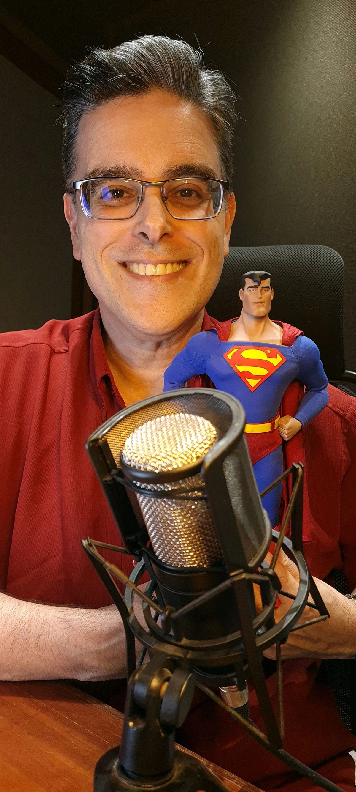 Guilherme Briggs e um boneco do Superman, um dos personagens que ele dubla