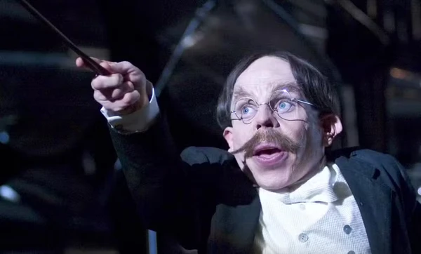 Warwick Davis como  Filius Flitwick por Divulgação