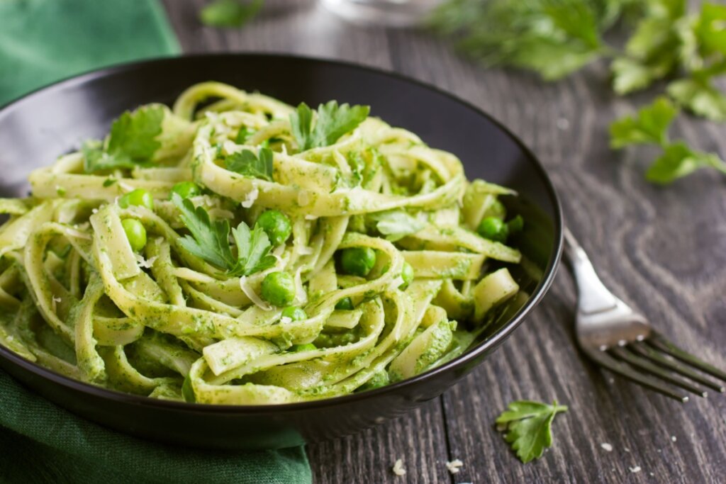 Macarrão com molho cremoso de espinafre e ervilha (Imagem: Anna Shepulova | Shutterstock)
