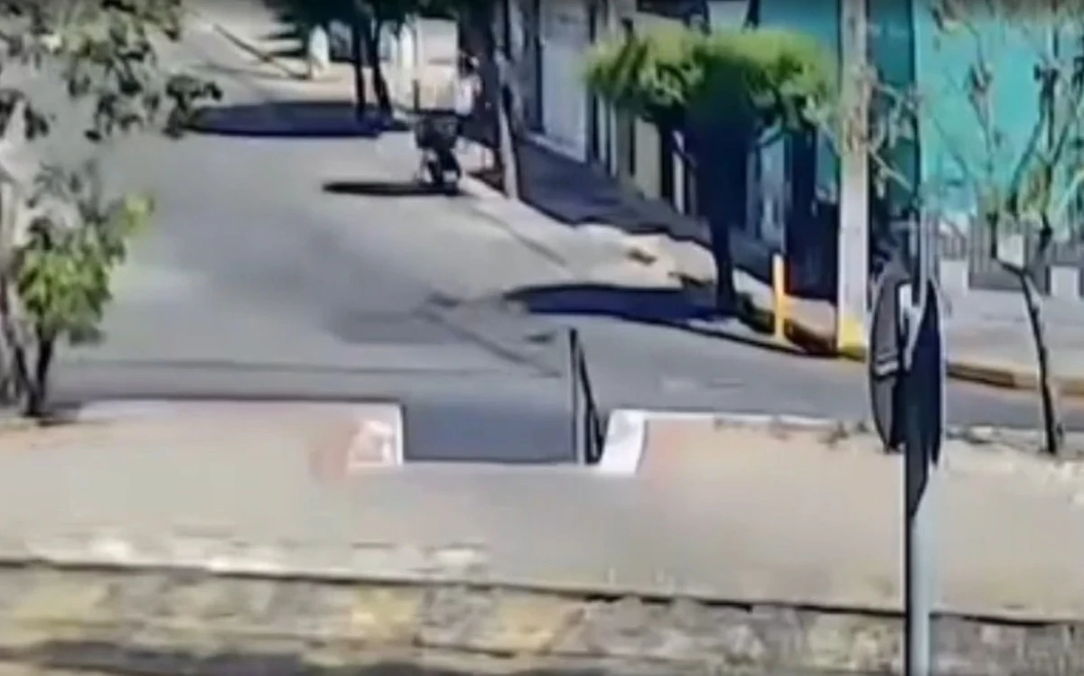 Os dois homens param a moto em rua ao lado da escola por Reprodução