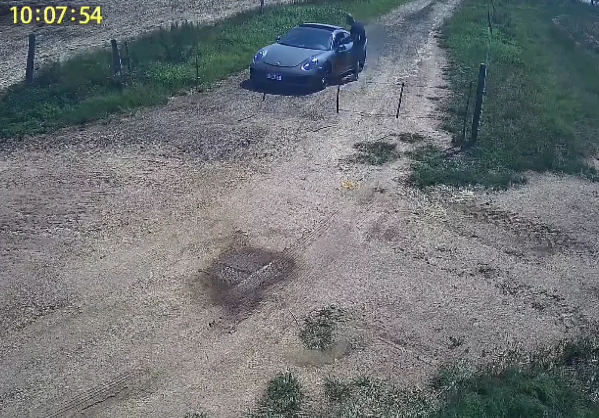 Ele aponta em direção a janela do carro por Reprodução