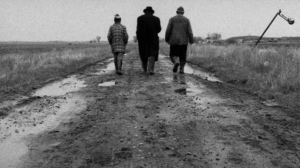 Cena de 'Satantango' (1994), de Béla Tarr: uma aldeia húngara vive na expectativa da chegada de Irimiás, um homem que se acreditava morto, tido como uma espécie de profeta por Divulgações