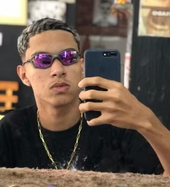 Jovem foi baleado na frente de uma loja de açaí por Reprodução