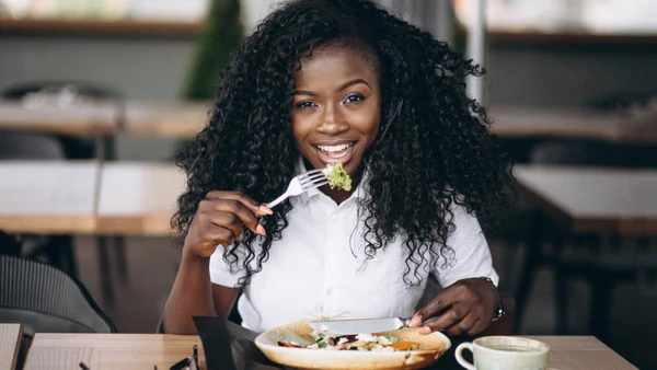 African american business woman eating salad in a cafe
