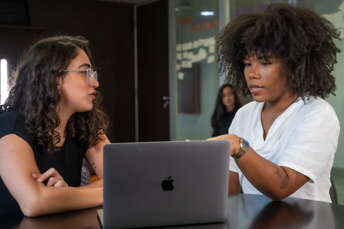 Jovens em reuniÃ£o e utilizando equipamentos eletrÃ´nicos.