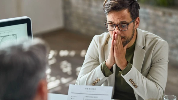 Distraught young man feeling uncertain while having a job interview in the office.