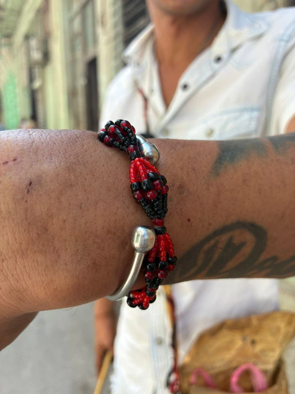 Bracelete nas cores vermelha e preta, em referência a Elegguá por André Uzêda