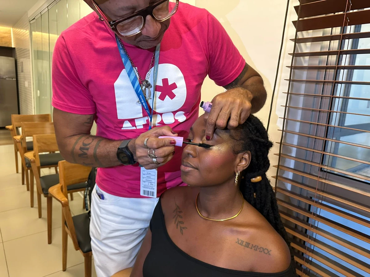 Dino Neto maquia modelo com uma das belezas definidas para o desfile por Correio