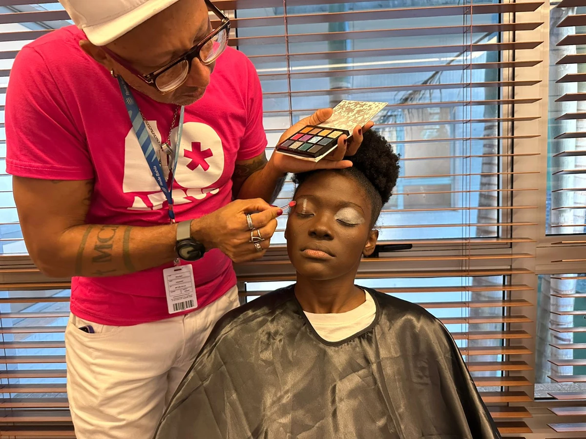 Dino Neto maquia modelo com uma das belezas definidas para o desfile por Correio