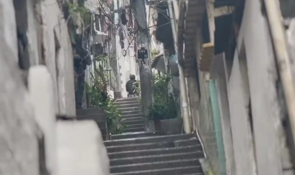 Agentes das forças de segurança em escadaria no Complexo do Alemão por Reprodução