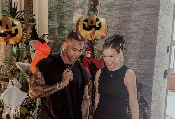 Leo Santana e Lore Improta olham impressionados para fantasia da filha