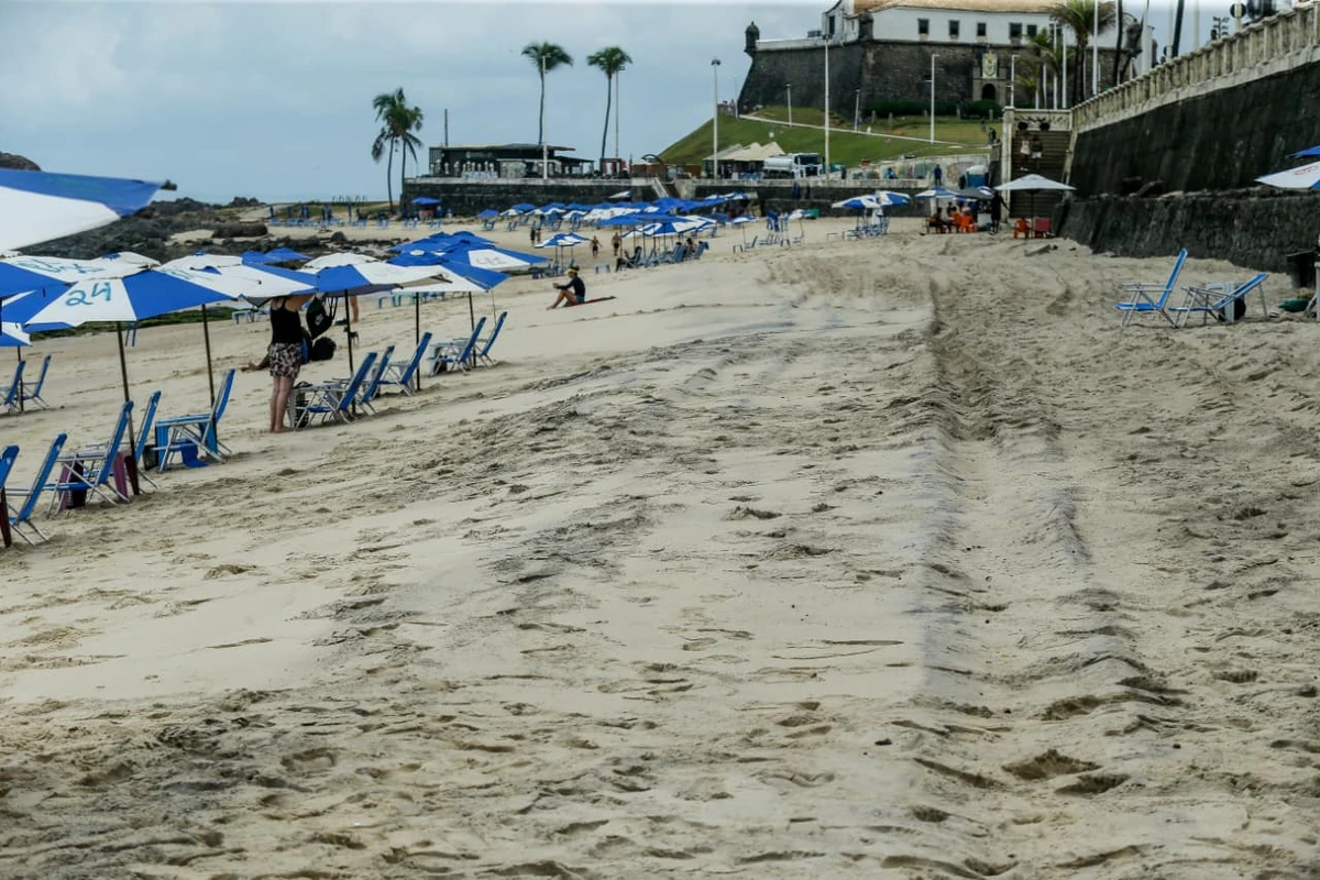Areia da praia da Barra tem chamado atenção por coloração escura por Arisson Marinho/CORREIO