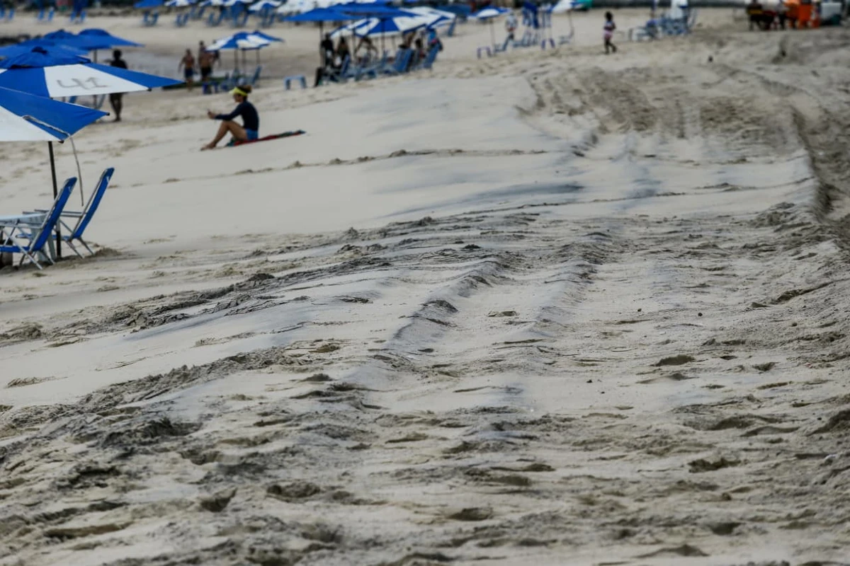 Areia da praia da Barra tem chamado atenção por coloração escura