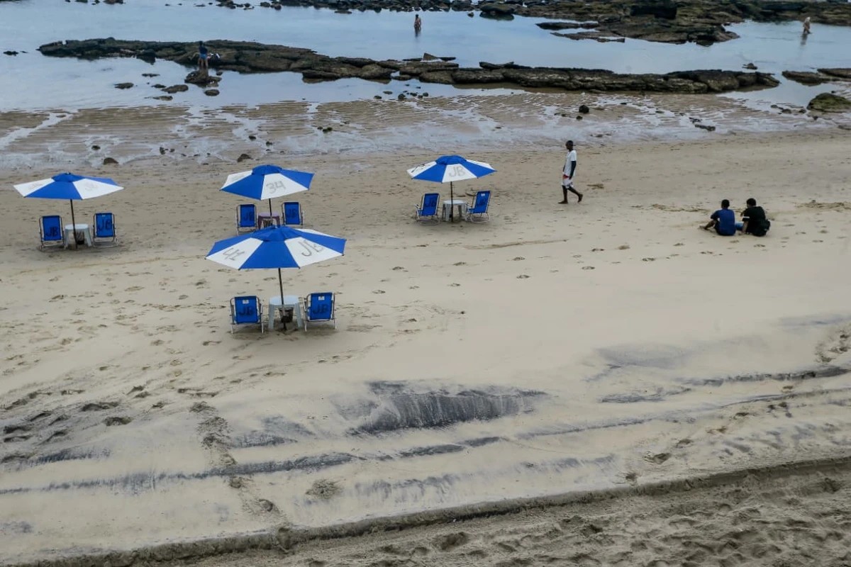 Areia da praia da Barra tem chamado atenção por coloração escura por Arisson Marinho/CORREIO