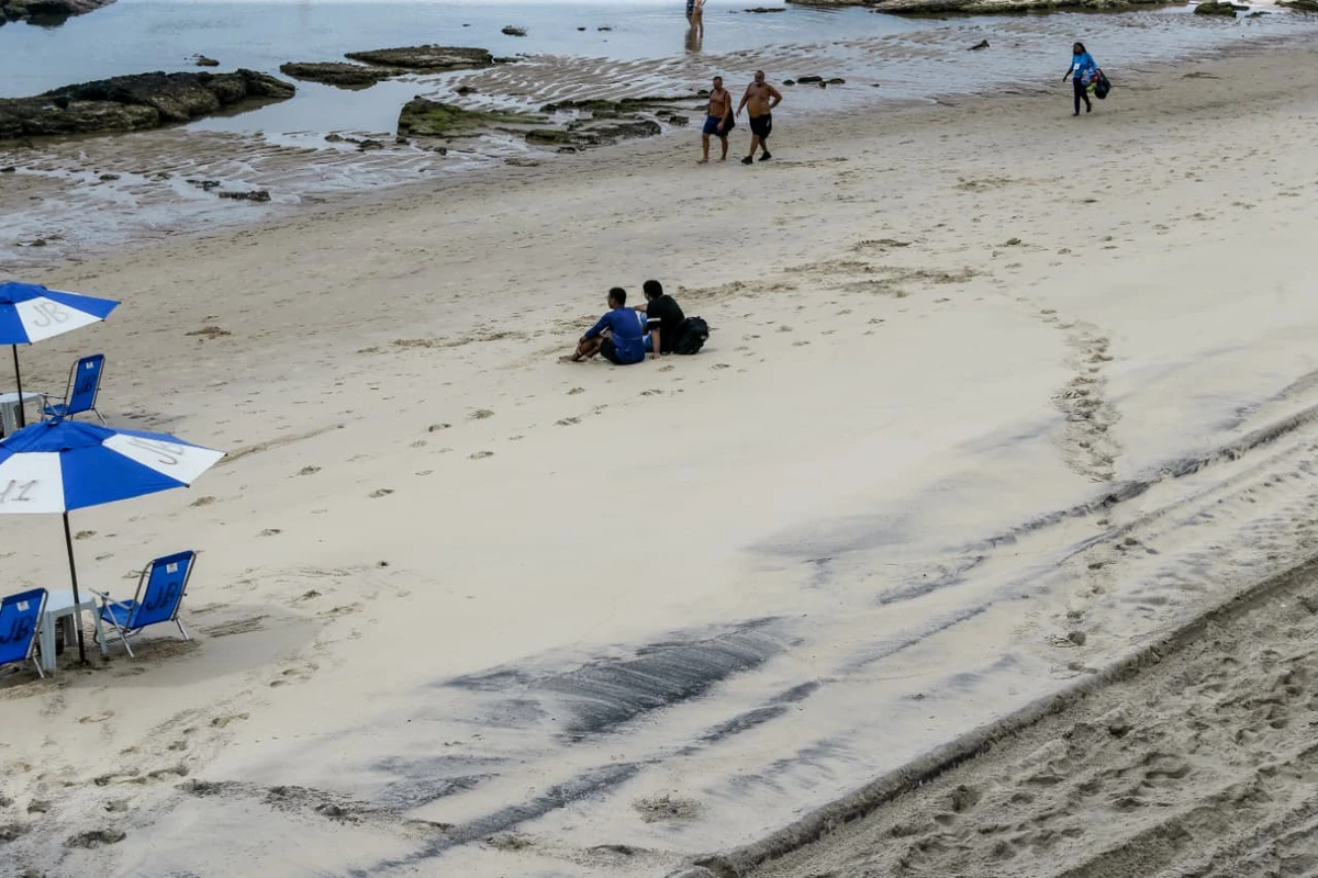 Areia da praia da Barra tem chamado atenção por coloração escura por Arisson Marinho/CORREIO